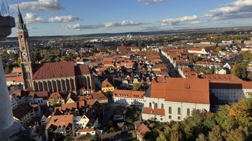2025 10 18 KDFB Landshut RN02 - Im Oktober 2025 fuhr eine Gruppe des Frauenbund Tutzing nach Landshut. Die Stadtführerin Jutta Beer vom Tourismusbüro der Stadt empfing uns sehr herzlich. Wir gingen zunächst in den Rathaussaal, der mit Wandmalereien der Landshuter Hochzeit ausgestattet und bereits 140 Jahre alt ist. Hier wurden damals wichtige Entscheidungen getroffen. Heute finden hier Konzerte und Empfänge statt. Wir erfuhren allerlei nette Geschichten und Bräuche der damaligen Zeit, so zum Beispiel, dass die Hochzeit vor 500 Jahren die teuerste und größte mit 10.000 Gästen war, eine Woche gedauert hat und umgerechnet 20 Mio Euro gekostet hat. Die Stadt hatte Geld, da hier die Steuer und der Zoll erfunden wurden. Sie erzählte uns, dass die polnische Braut mit 18 Jahren schon zu alt war, aber der Herzog auch erst 20 war und so es ein guter Start für die Ehe war. Am Hochzeitstag gab es ein 35-Gänge Menü und wir stellten uns vor, wie man so viel Essen kann und wie man sich dabei wohl fühlt.