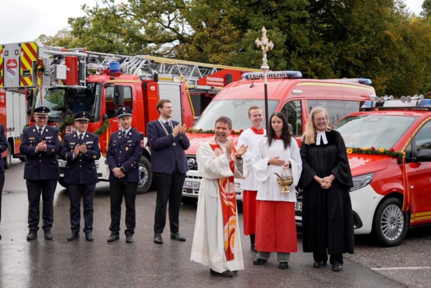 Fahrzeugweihe in Tutzing 1 2026 10 10 Fahrzeugweihe FFW01 - Mit Gottesdienst und Festzug feierte die Freiwillige Feuerwehr Tutzing am Samstag 10. Oktober 2026 die Weihe von vier neuen Fahrzeugen und einem Anhänger im Gesamtwert von rund 1,37 Millionen Euro. Darunter ist eine Drehleiter für rund eine Million Euro. Pfarrer Peter Seidel und Pfarrerin Beate Frankenberger segneten die neuen Einsatzmittel und setzten damit ein Zeichen gelebter Ökumene. Die Ausstattung stärkt die Feuerwehr bei Rettungseinsätzen, Gefahrgutlagen und dem Gewässerschutz.